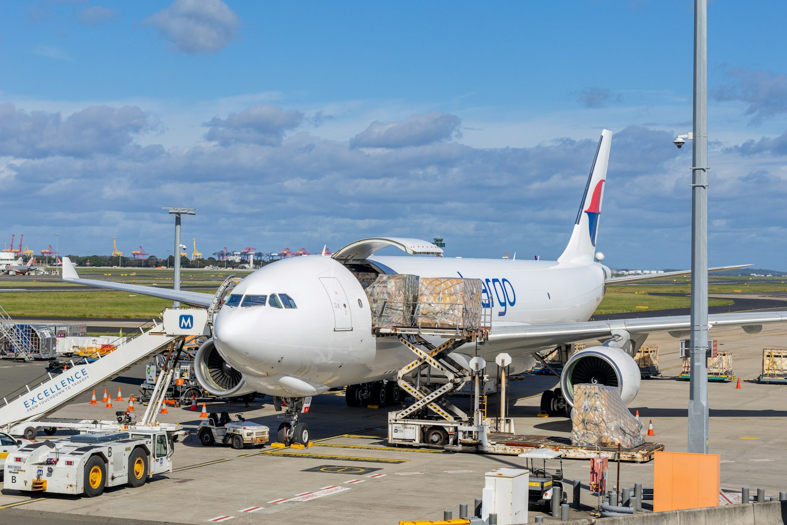 Avião cargueiro sendo carregado em pátio aeroportuário